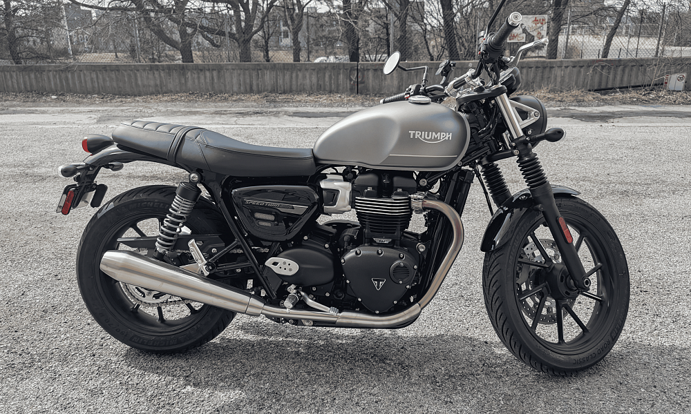 Side profile of Grey Triumph motorcycle in parking lot 
