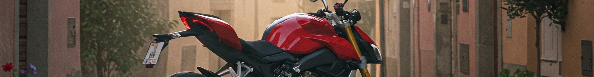 Rear image of a red Ducati Streetfighter motorcycle parked in the street of an Italian town