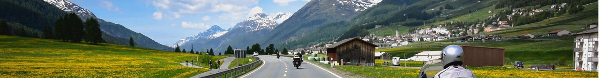 Motorcycle riders in a group ride, riding on a long stretch of roadway