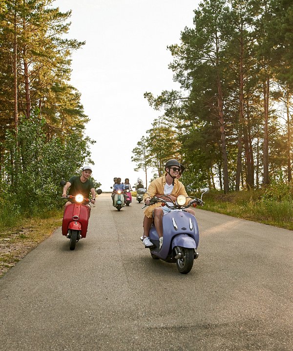 Group of motorcycle riders hanging out with their motorcycles in a parking lot with Chicago skyline in the backdrop