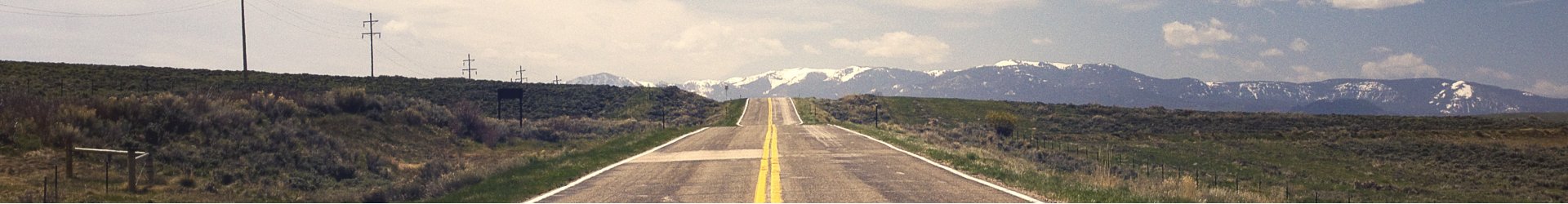 open highway road leading to a mountain backdrop